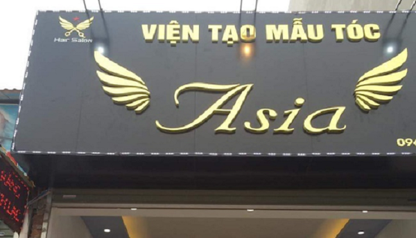 Biển quảng cáo chữ nổi màu vàng kết hợp nền đen ấn tượng của salon tóc